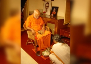 Kitten sitting on Swamiji's lap during Pushpasamarpanam
